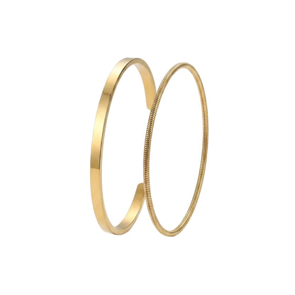 Two gold-toned bangles, one with a smooth polished finish and the other with a textured snake-style border, displayed on a clean white background.